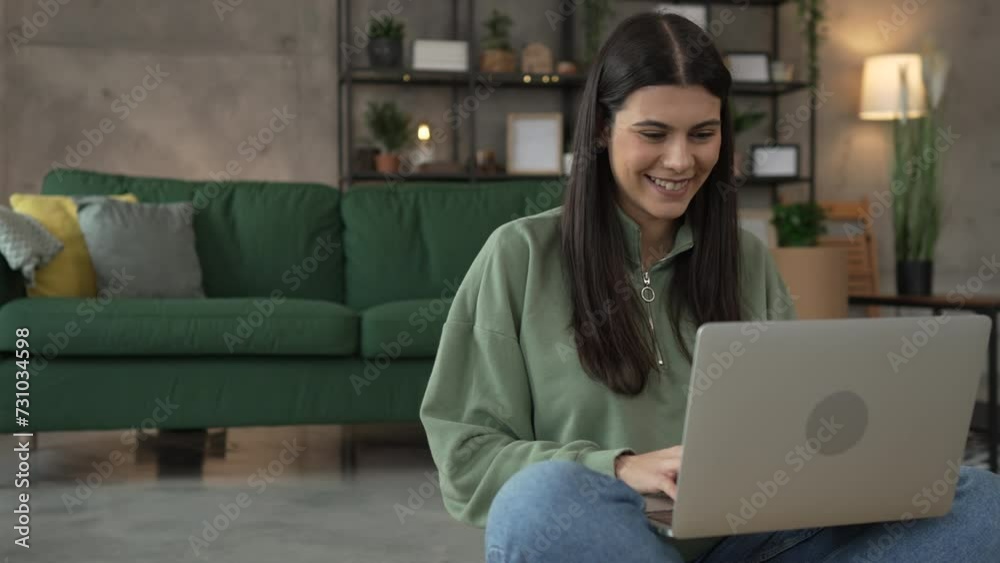 One young woman use laptop computer at home while sit comfortable One young woman use laptop computer at home while sit comfortable