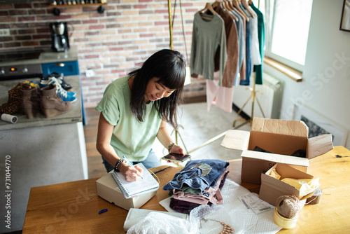 Asian Woman Packing Clothes at Home Business