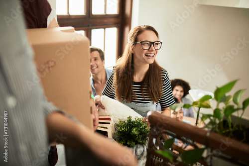 Diverse group of young people moving in their new shared apartment and carrying boxes photo
