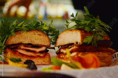 Chicken schnitzel in the Challah. Israeli street food. Challah sandwich - sabich. Eggplant, grilled hot pepper photo