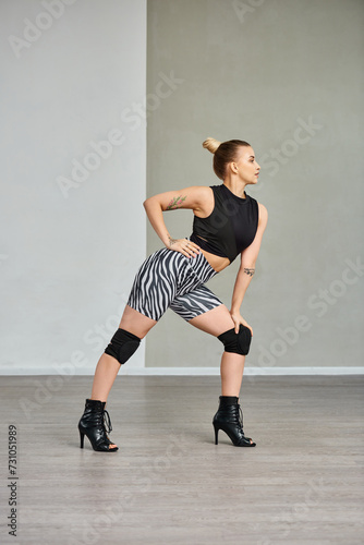 A graceful dancer effortlessly balances on the tips of her toes in sleek high heels and black top