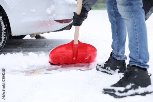 Man removing snow with shovel near car outdoors, closeup © New Africa