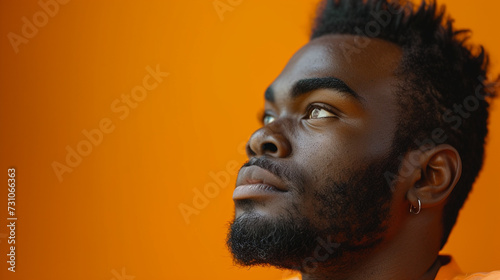 Portrait of an African-American black man, close-up face, critical emotional serious or implausible facial expression, thoughtful or doubtful, prejudiced and reproachful photo