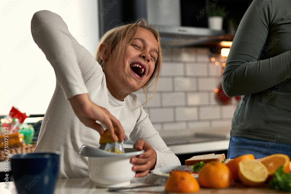 Laughter echoes in the kitchen as mother and daughters squeeze oranges, creating a refreshing touch to their delightful breakfast. Laughter echoes in the kitchen as mother and daughters squeeze oranges, creating a refreshing touch to their delightful breakfast.