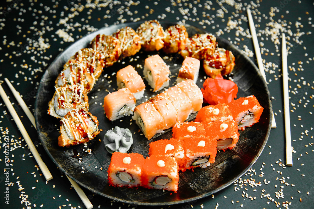 Freshly Prepared Sushi on a Black Plate With Chopsticks