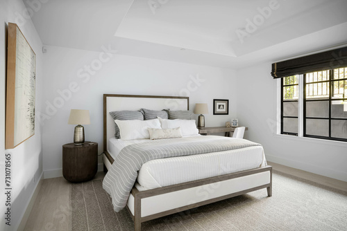 Large white bed with white pillows and grey blankets and pillow covers