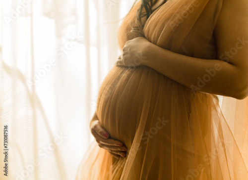 Schwangere Frau im schönen orangenen Kleid photo