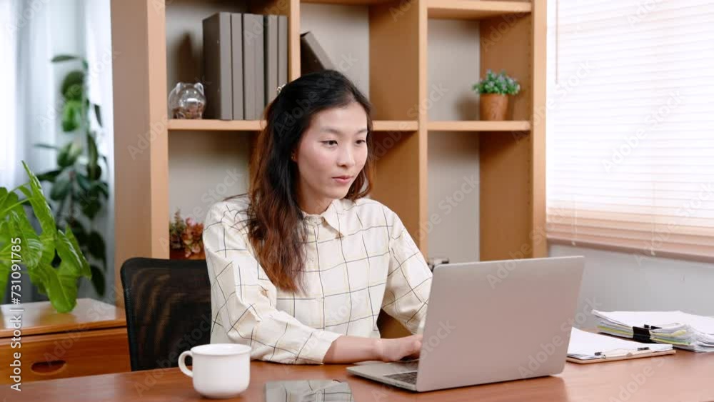 Young Asian office woman, with laptop computers at front desk, in private offices, sit work with smiles on their face no worries about work that needs be done, woman is happy with office work. Young Asian office woman, with laptop computers at front desk, in private offices, sit work with smiles on their face no worries about work that needs be done, woman is happy with office work.