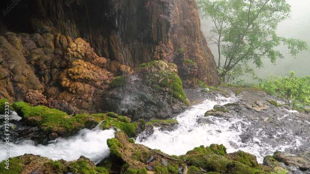Goa Tetes waterfall. Many streams flow over the stones against the backdrop of beautiful nature. Lumajang Province, East Java, Indonesia Goa Tetes waterfall. Many streams flow over the stones against the backdrop of beautiful nature. Lumajang Province, East Java, Indonesia