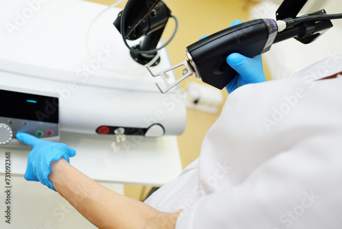 cosmetologist holds a CO2 fractional ablative laser for skin rejuvenation and scar removal in his hands and prepares for the procedure.Laser cosmetology