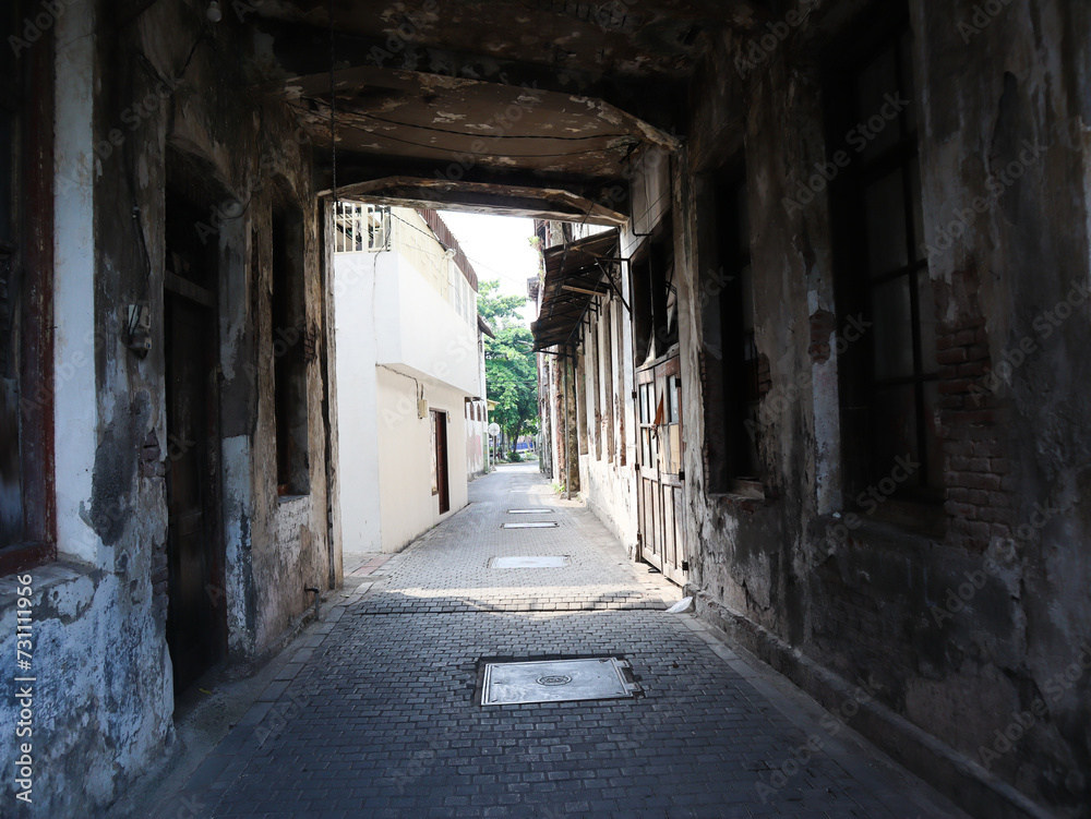 an alley with a small tunnel leading to the street. surabaya, indonesia - 4 january 2024 an alley with a small tunnel leading to the street. surabaya, indonesia - 4 january 2024