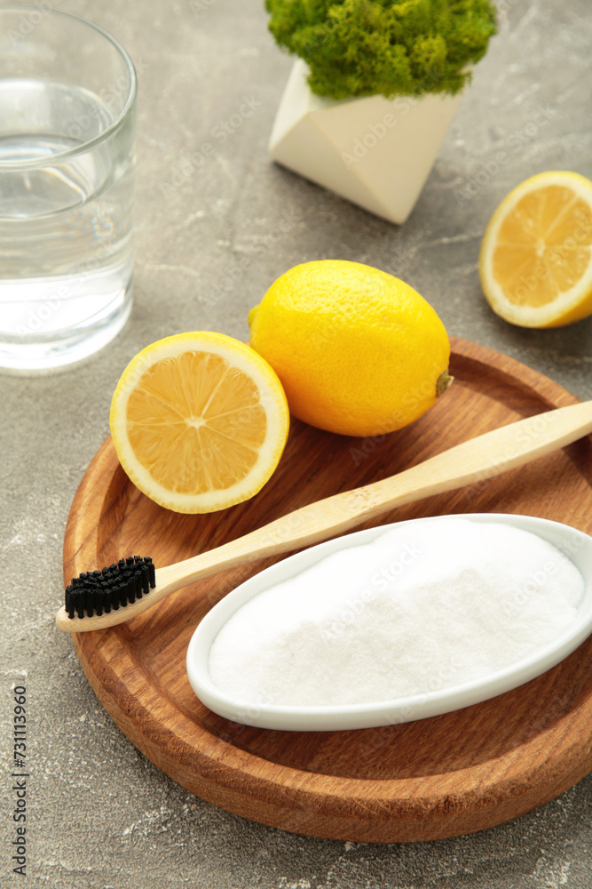 Toothbrush with lemon and baking soda on grey background. Vertical photo Toothbrush with lemon and baking soda on grey background. Vertical photo