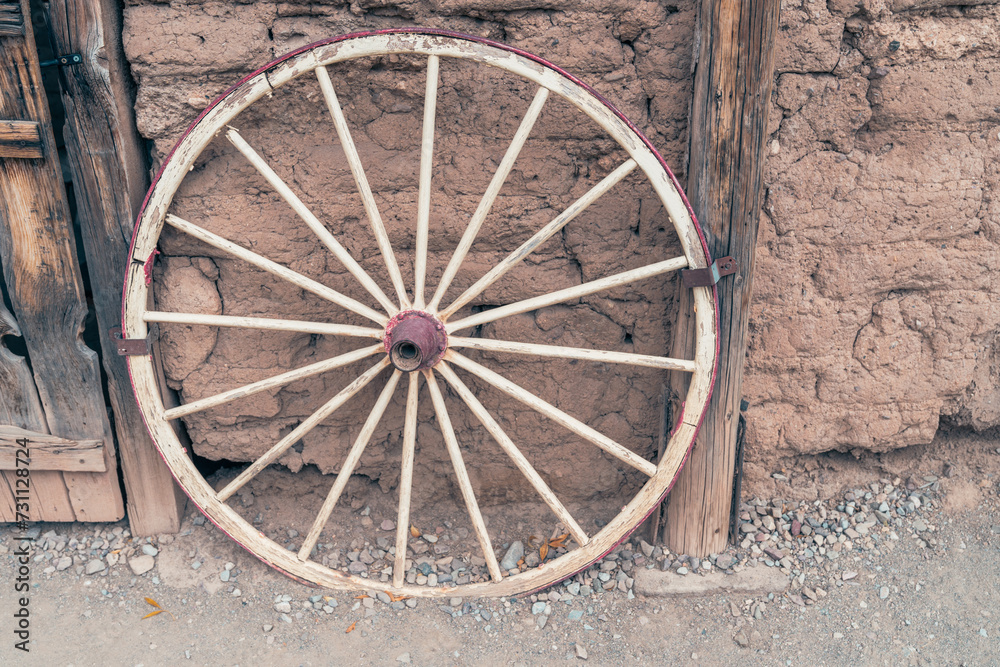 Antique wagon wheel against a wall