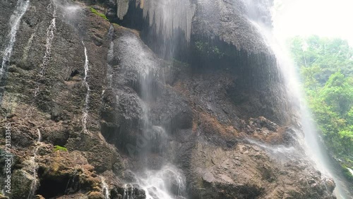 Goa Tetes waterfall. Many streams flow over the stones against the backdrop of beautiful nature. Lumajang Province, East Java, Indonesia photo