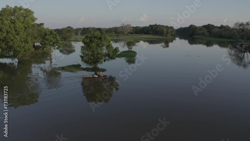 a local resident paddles a canoe towards his house on stilts, built in a flooded area (igapó) near the city of Manaus (AM), in the Brazilian Amazon.