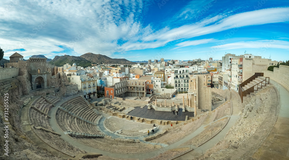 Panoramic view of the Roman Amphitheater in Cartagena Spain with dramatic cloudy blue sky background