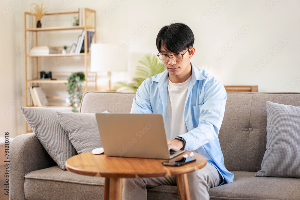 Businessman in casual is sitting comfortable sofa to thoughtful of idea for new business while using laptop Businessman in casual is sitting comfortable sofa to thoughtful of idea for new business while using laptop