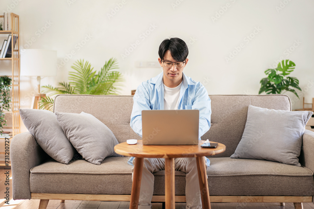 Businessman in casual is sitting comfortable sofa to thoughtful of idea for new business while using laptop Businessman in casual is sitting comfortable sofa to thoughtful of idea for new business while using laptop