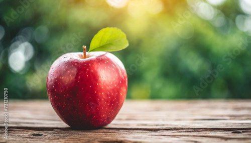 red apple rests on table, backdrop of nature, with space for caption