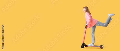 Canvas Print Portrait of panicked businesswoman riding kick scooter on yellow background with