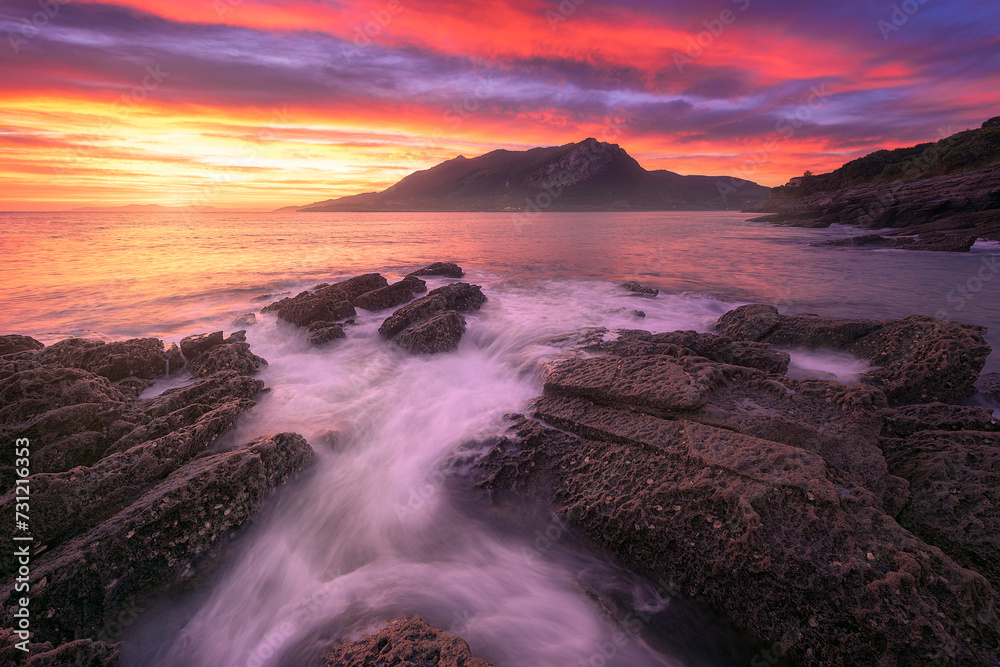 Sonabia beach at sunrise with the Sonabia beach at sunrise with the water between the rocks in the foreground
