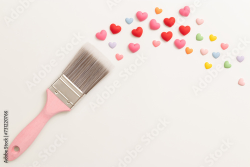 pink wooden handle paint brush, painting colorful tiny heart shaped isolated on white background, decorate for Valentine's Day celebration background with copy space. romantic love relationship