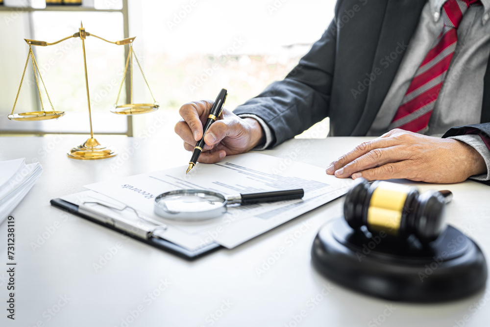 Male lawyer or judge working with contract papers, Law books and wooden gavel on table in courtroom, Justice lawyers at law firm, Law and Legal services concept Male lawyer or judge working with contract papers, Law books and wooden gavel on table in courtroom, Justice lawyers at law firm, Law and Legal services concept