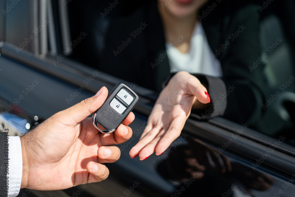 Young asian businesswoman buying new car with sale manager. she getting key and go to driving car very happy and proud. Buy sell rent concept. Hand sending key vehicle contract business car deal