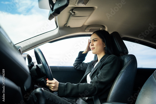 Driving during rush hour But the traffic is very congested. Angry face. Young asian businesswoman has broken down car on the road she feeling serious and stressed. Car crash Look for someone help. © Chanakon