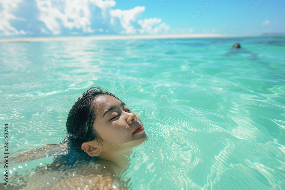 Young beautiful Asian woman swimming Along the pristine white sand beach green sea water High quality photos
