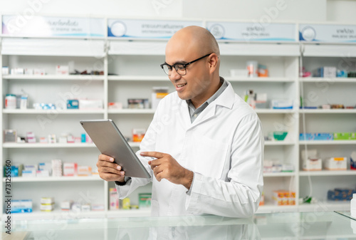 Wallpaper Mural Professional asian man pharmacist checks inventory arrangement of medicine in pharmacy drugstore. Male Pharmacist wearing uniform standing near drugs shelves counter prescription to customers Torontodigital.ca
