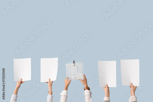 Hands holding ballot box and voting papers on light background. Election concept