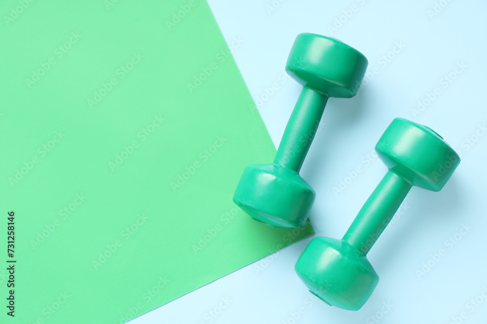 Pair of green dumbbells on color background Pair of green dumbbells on color background