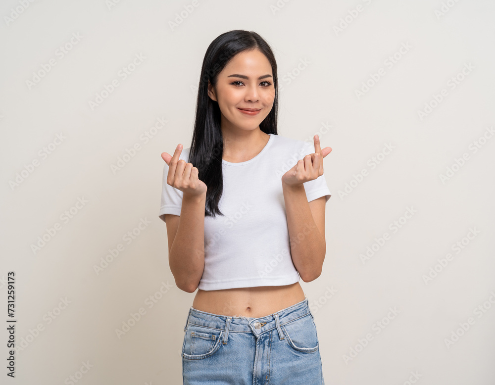 Pretty Young beautiful Asian woman standing and smiling showing mini heart sign on isolated white background. Attractive Lovely Latin female wearing white shirt feeling surprised and happy. Pretty Young beautiful Asian woman standing and smiling showing mini heart sign on isolated white background. Attractive Lovely Latin female wearing white shirt feeling surprised and happy.