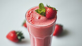 Close up of a glass of fresh strawberry smoothie with strawberry fruits on white background