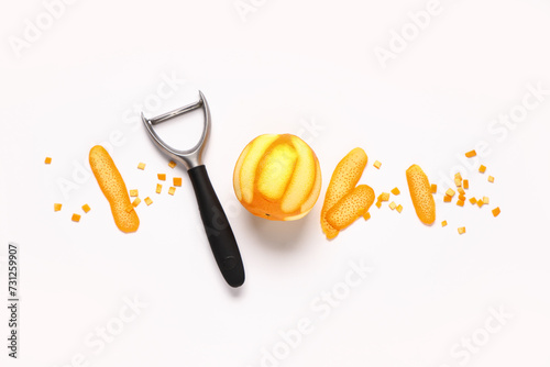 Composition with fresh ripe orange and peeler on white background photo