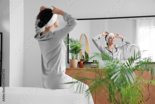 Young African-American woman with headband in bathroom