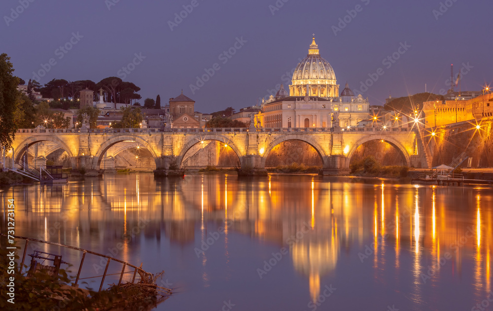Bridge of the Holy Angel in Rome at night illuminated at sunset.
