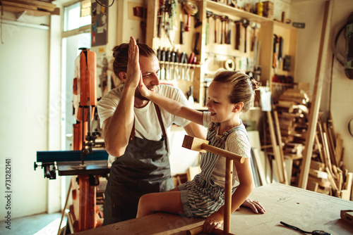 Father and daughter enjoying woodworking in a home workshop photo