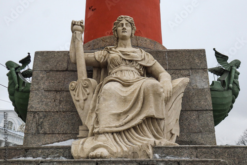 Sculpture of a woman on the Rostral column, symbolizing the Russian river on the spit of Vasilyevsky Island in St.Petersburg, Russia  photo