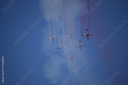 Airshow of aerobatic planes showcasing parachutes paramotor skydiving show with colors 