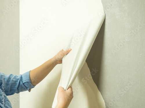 girl tears off old wallpaper and makes renovations in the apartment