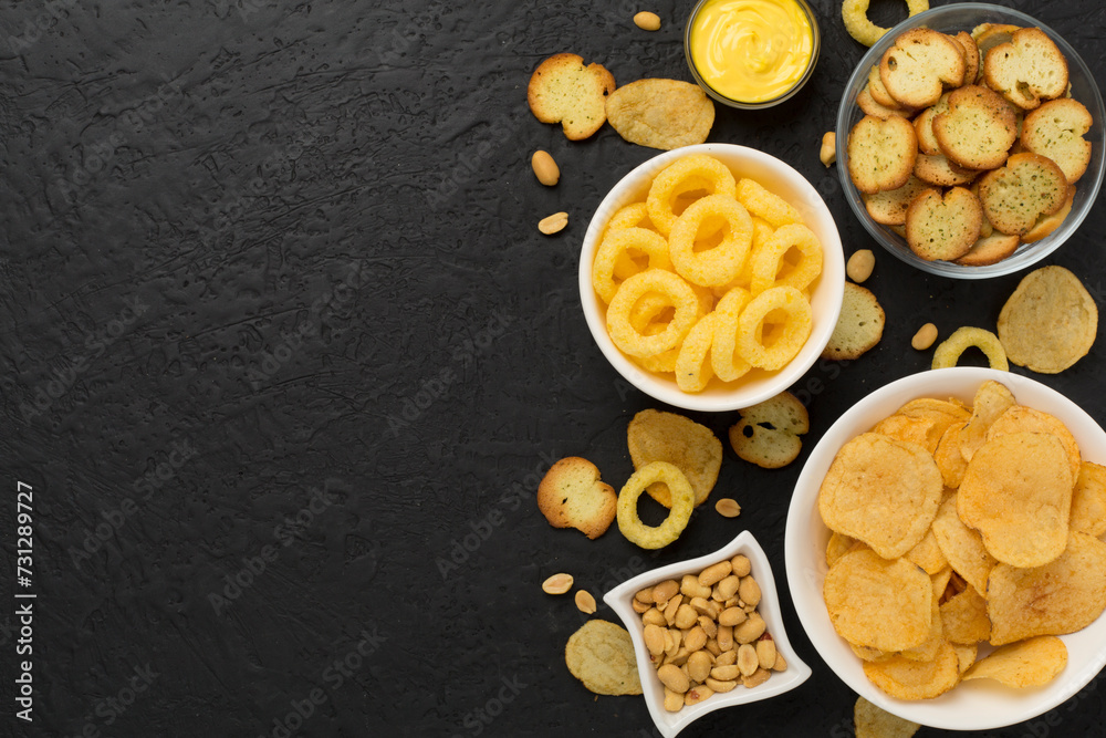 Various unhealthy snacks on concrete background, top view