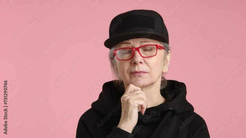 An elderly woman wearing glasses and a black hat contemplates with her eyewear, thinking about vision care and potentially adjusting her sleeve. An elderly woman wearing glasses and a black hat contemplates with her eyewear, thinking about vision care and potentially adjusting her sleeve.