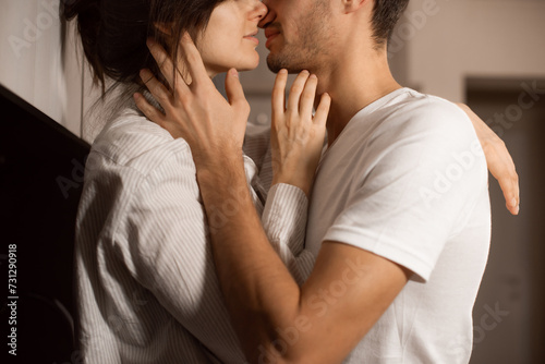closeup kiss and hugs couple in love wearing white domestic clothes