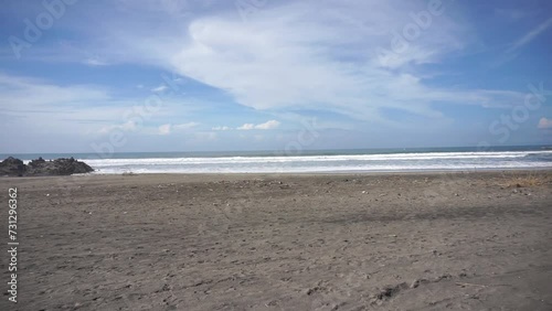 Beautiful video of beachside views, natural panoramas, sea water accompanied by crashing waves and coral rocks with cloudy skies during the day, on Karang Paranje beach, Garut photo