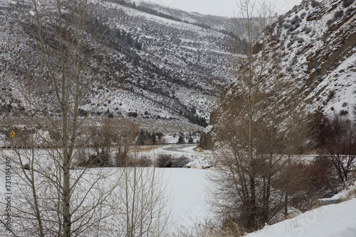 Icy Interstate 70 on-ramp in winter as seen through aspen trees.   photo