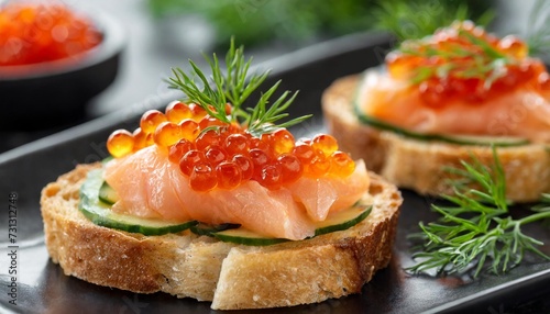 closeup of appetizers toast with salmon and lumpfish roe in a black plate lumpfish roe