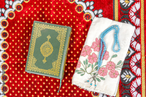 Rahle with Quran and Rosary on Muslim prayer rug.Ramadan Concept