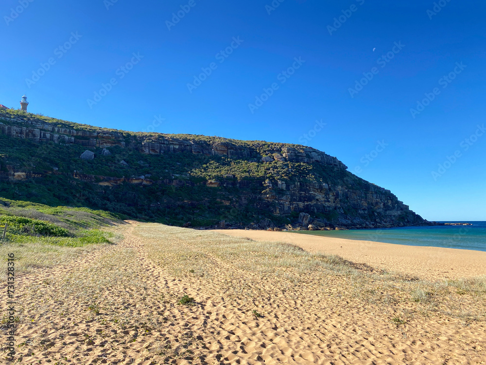 Mountains with a lighthouse on the top. The island's coastline with beach and hill. Mountains with a lighthouse on the top. The island's coastline with beach and hill.